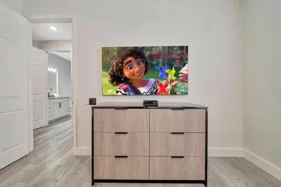 a living room with a flat screen tv on a dresser at Vista Cay Getaway · Orlando Stay in Orlando