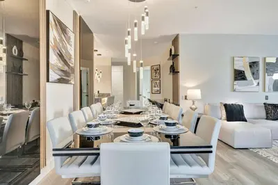 a dining room with a long table and white chairs at Vista Cay Getaway · Orlando Stay in Orlando