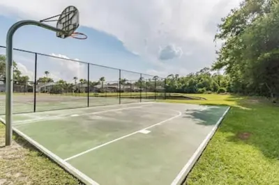 an empty tennis court with a basketball hoop at Spacious Home · Near Disney Parks in Kissimmee