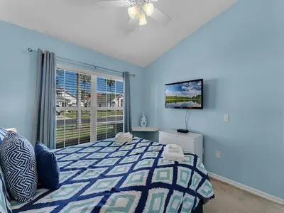 a blue bedroom with a bed and a window at Spacious Home · Near Disney Parks in Kissimmee