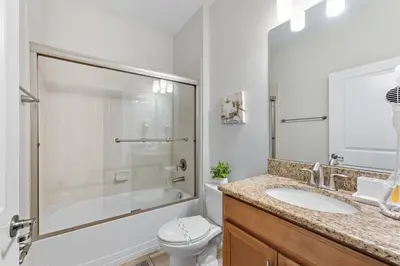 a bathroom with a shower and a toilet and a sink at Spacious 6BR Pool Resort - Near Disney in Kissimmee