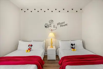 a bedroom with two beds with red sheets at Orlando Family Stay · Pool Clubhouse in Kissimmee