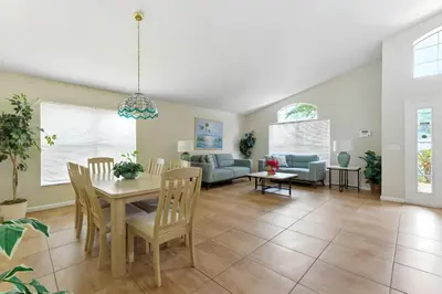 a dining room and living room with a table and chairs at Cozy No-Carpet Home Heated Pool Disney in Kissimmee
