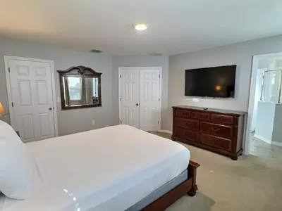 a bedroom with a bed and a flat screen tv at Family Getaway wPvt Pool close to Disney in Kissimmee