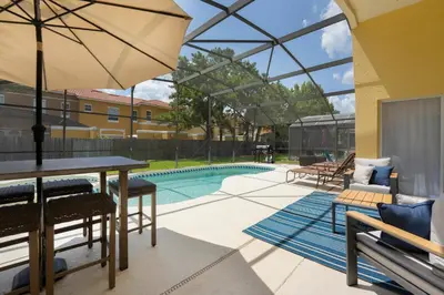 a patio with a table and chairs and a pool at Two Master Suites Private Pool in Kissimmee