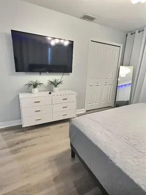 a bedroom with a flat screen tv on a white dresser at Family Getaway near Disney Sleeps 13 in Kissimmee