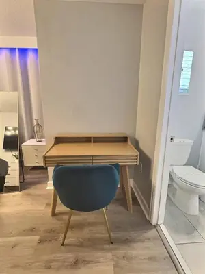 a desk with a blue chair in a room with a toilet at Family Getaway near Disney Sleeps 13 in Kissimmee