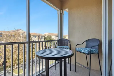 a table and two chairs on a balcony with a view at 3BR Windsor Hills Condo Water Park and Skeeball Near Disney No Resort Fees in Orlando