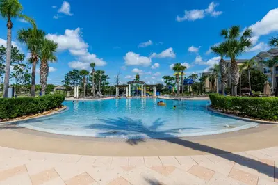 a swimming pool at a resort with palm trees at 3BR Windsor Hills Condo Water Park and Skeeball Near Disney No Resort Fees in Orlando