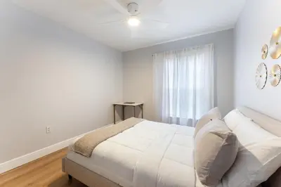 a white bedroom with a bed and a window at Family Townhouse 10 Min to Parks with Themed Room in Kissimmee
