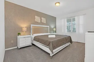 a bedroom with a large bed and a window at Spacious Disney-Area Home with Private Pool in Kissimmee
