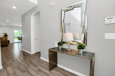 a hallway of a home with a console table and a mirror at Spacious Disney-Area Home with Private Pool in Kissimmee
