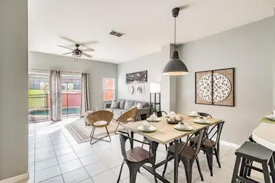 a dining room and living room with a table and chairs at Casa Moderna 3Q c/ Piscina Aquecida – 10min Disney in Kissimmee