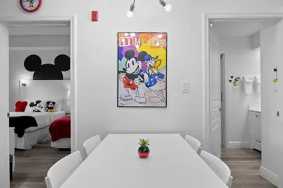 a white room with a white table and a bedroom at 2 Bedroom Deluxe - Theme Park in Orlando