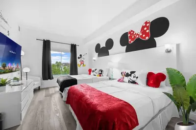 a bedroom with two beds and a mickey mouse headboard at 2 Queen Beds Theme Park in Orlando