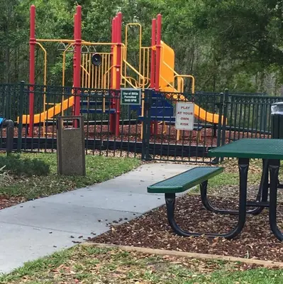 a park with a bench next to a playground at Venetian Bay Townhome townhouse in Kissimmee