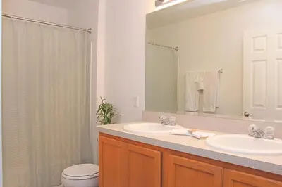 a bathroom with a sink and a toilet and a mirror at Berkeley Pool Home home in Kissimmee
