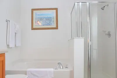 a white bathroom with a shower and a sink at Berkeley Pool Home home in Kissimmee