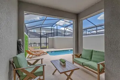 a living room with a couch and chairs and a pool at Top House with Private Pool and Resort in Kissimmee