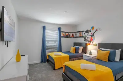 a bedroom with two beds with blue and yellow at Top House with Private Pool and Resort in Kissimmee