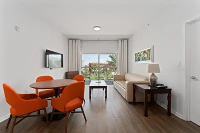 a living room with a couch and a table and chairs at Hotel Meliá Orlando in Orlando