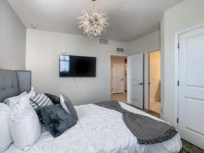 a bedroom with a bed with a television on the wall at 4731#208- 3BR Condo 10min Disney 2 WaterParks in Kissimmee
