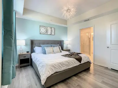 a bedroom with a large bed and a chandelier at 4731#301- 3BR Condo 10min Disney 2 WaterParks in Kissimmee