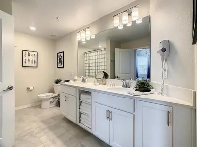 a bathroom with two sinks and a large mirror at 4731#301- 3BR Condo 10min Disney 2 WaterParks in Kissimmee