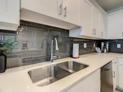 a kitchen with a stainless steel sink and white cabinets at 4731#301- 3BR Condo 10min Disney 2 WaterParks in Kissimmee