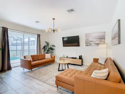 a living room with two couches and a tv at 4774 - 7BR w Pool 10min Disney 2 Water Parks in Kissimmee