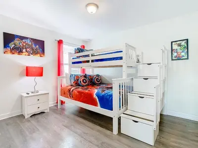 a bedroom with a white bunk bed and a bedside table at 4774 - 7BR w Pool 10min Disney 2 Water Parks in Kissimmee