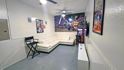 a living room with a white couch and posters on the wall at 4774 - 7BR w Pool 10min Disney 2 Water Parks in Kissimmee