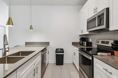 a kitchen with white cabinets and stainless steel appliances at Luxo Storey Lake | 5Q Piscina Aquecida & Resort in Kissimmee
