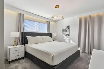 a white bedroom with a bed and a window at Luxo Storey Lake | 5Q Piscina Aquecida & Resort in Kissimmee