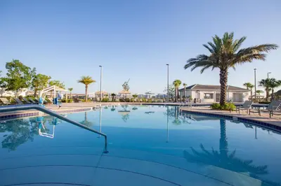 a large swimming pool with palm trees in a resort at 4809 - 5BR w Pool 10min Disney 2 Water Parks in Kissimmee