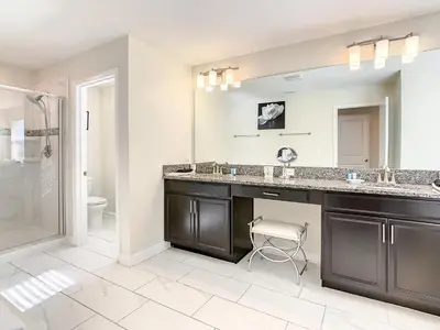 a bathroom with a sink and a toilet and a mirror at 4809 - 5BR w Pool 10min Disney 2 Water Parks in Kissimmee