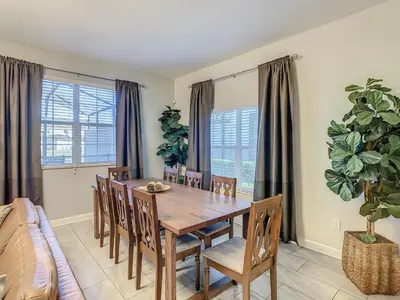 a dining room with a wooden table and chairs at 4916 - 5BR w Pool 10min Disney 2 Water Parks in Kissimmee