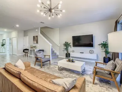 a living room with a couch and a table at 4916 - 5BR w Pool 10min Disney 2 Water Parks in Kissimmee