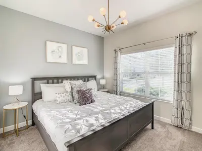 a bedroom with a large bed and a window at 4916 - 5BR w Pool 10min Disney 2 Water Parks in Kissimmee