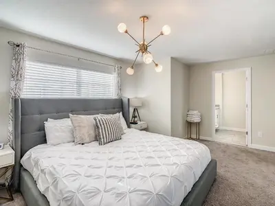 a bedroom with a large bed and a chandelier at 4916 - 5BR w Pool 10min Disney 2 Water Parks in Kissimmee