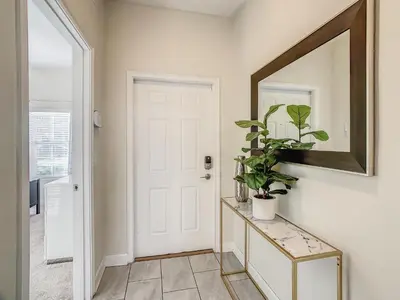 a hallway with a white door and a mirror at 4916 - 5BR w Pool 10min Disney 2 Water Parks in Kissimmee