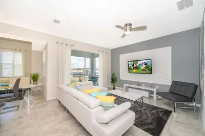 a living room with a white couch and a tv at Lake View Condo Near Disney in Kissimmee