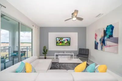 a living room with a white couch and a tv at Lake View Condo Near Disney in Kissimmee