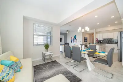 a dining room and living room with a table and chairs at Lake View Condo Near Disney in Kissimmee