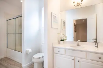 a white bathroom with a sink and a toilet at Veranda Palms 6BR Pool Near Disney Parks in Kissimmee