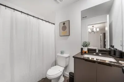 a white bathroom with a toilet and a sink at Family 3BR Home Minutes from Disney in Kissimmee