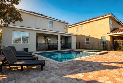 a house with a swimming pool in a yard at 6BR Home w Theater Pool Near Disney in Orlando