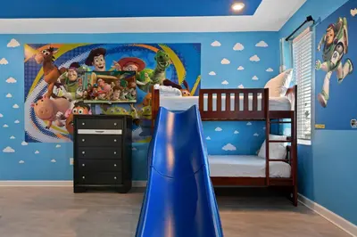 a childs bedroom with a dinosaur mural on the wall at Spacious 9BR w Pool Theater at Storey Lake in Kissimmee