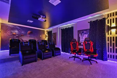 a room with a bunch of chairs in it at Spacious 9BR w Pool Theater at Storey Lake in Kissimmee