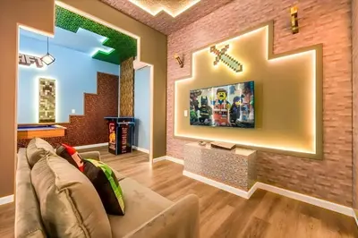 a living room with a couch and a tv on a brick wall at Luxury 12BR Home w Pool Game Room in Orlando